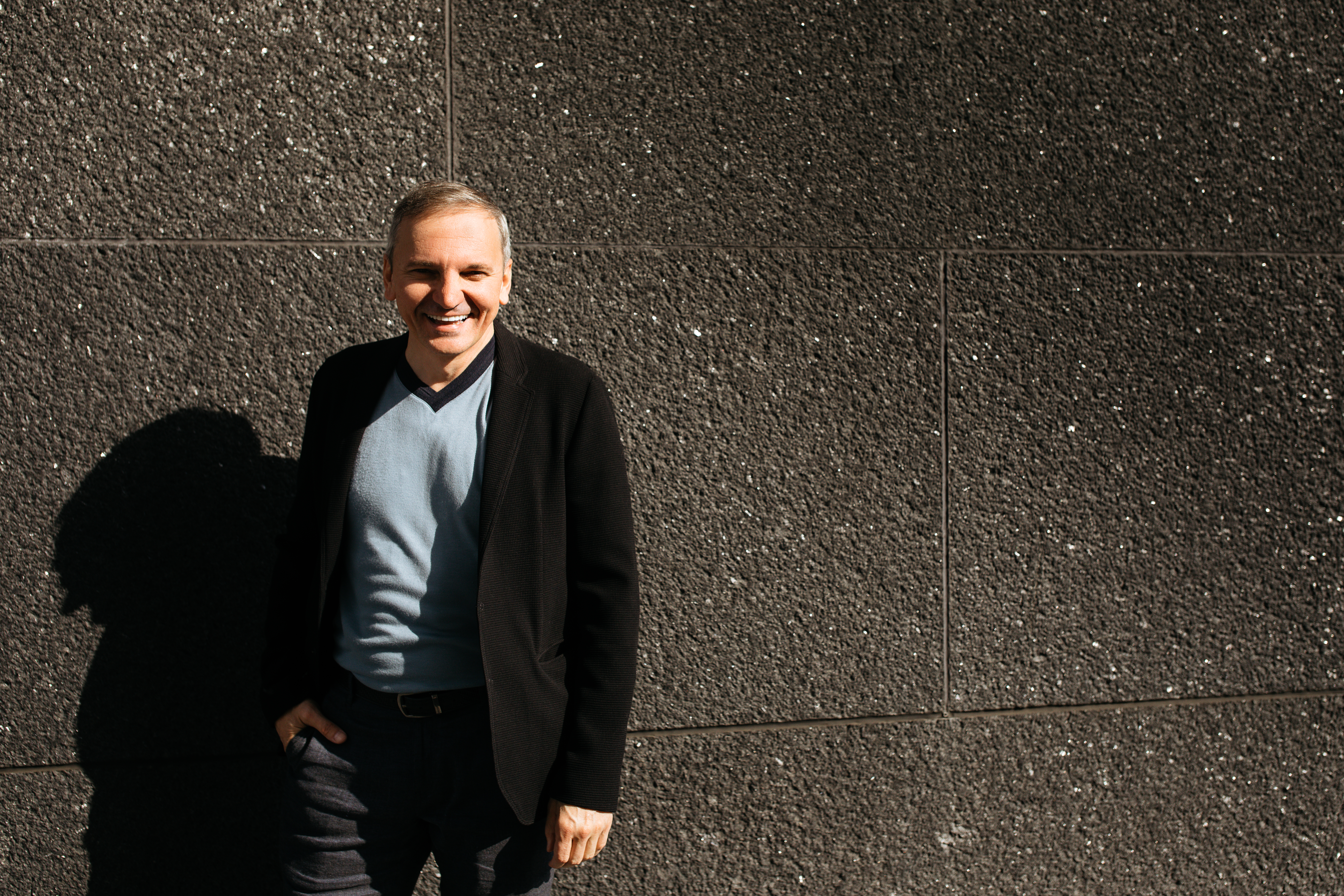 Maksim Grinberg standing in front of a solid rock wall