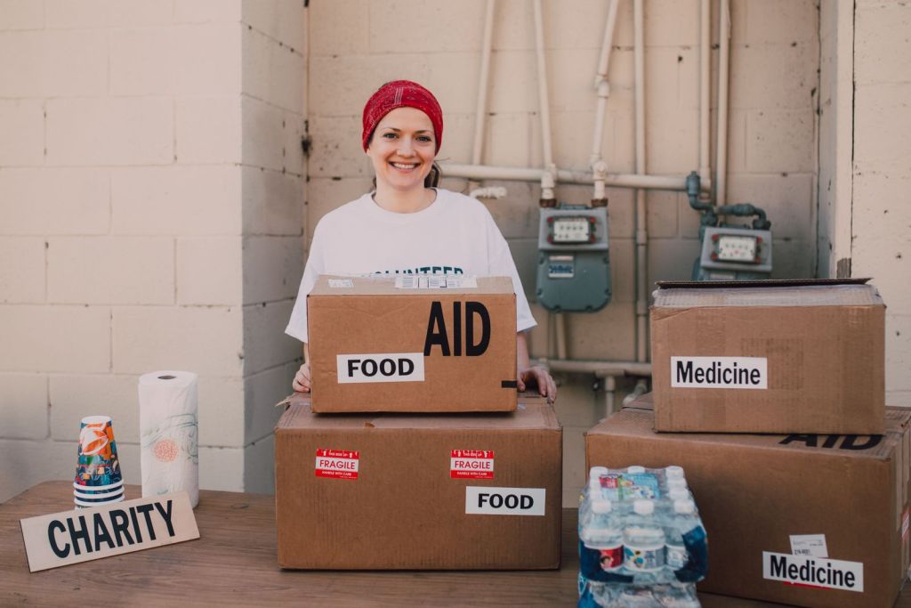 Volunteer handing out aid packages during charity work for Building Stronger Neighborhoods Through Volunteerism