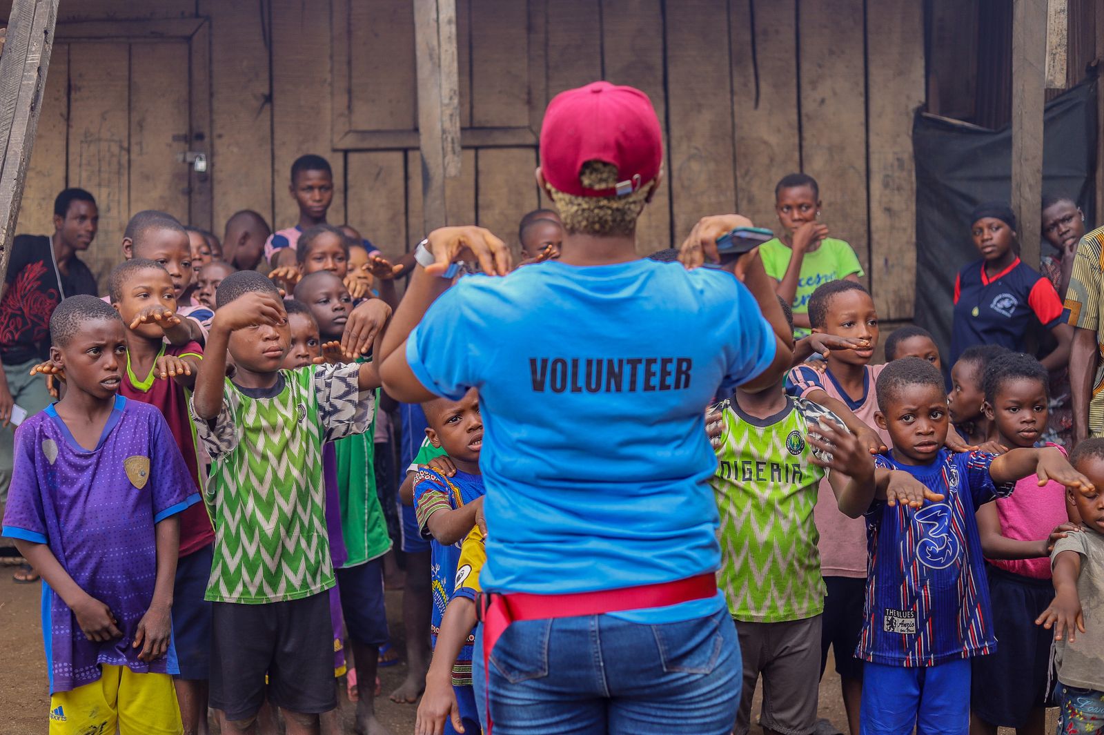 Volunteer supporting children during a community activity for How Literacy Programs Benefit Brooklyn Families